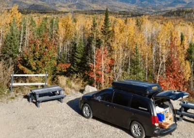 minivan aménagée au bord d'une foret en automne au Québec