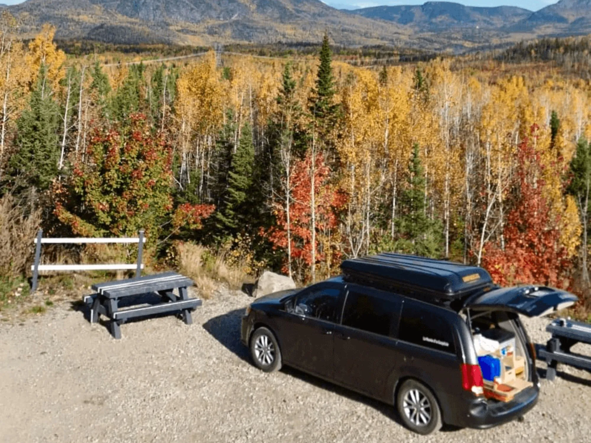 converted minivan by a forest in fall in Quebec